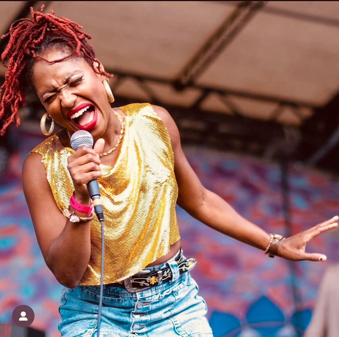 Tierinii Jackson Naftaly singing live — gold top, festival stage